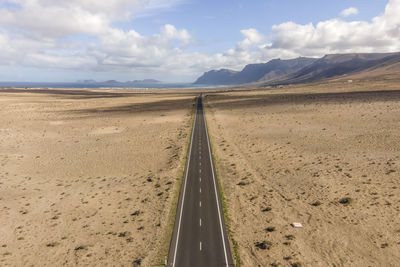 Aerial view of a road crossing a desert valley during a sunny day in teguise, lanzarote, canary 