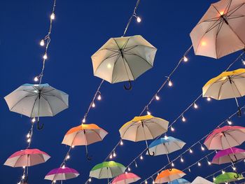 Low angle view of illuminated lanterns hanging against sky