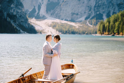 People on lake against mountain range