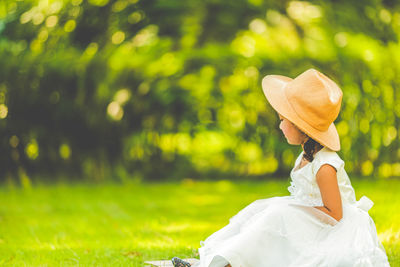 Rear view of woman wearing hat on field