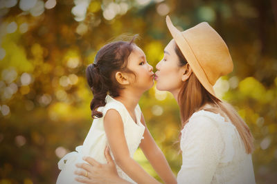 Side view of mother and daughter outdoors