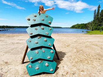 Tilt image of person on sea shore against sky