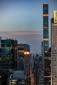 Modern buildings in city against sky at dusk