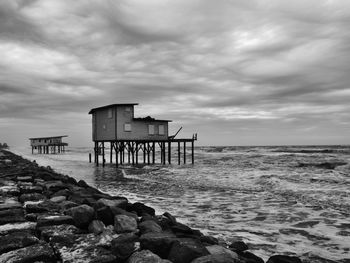 Stilt houses against cloudy sky