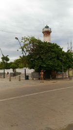 Trees by built structure against sky