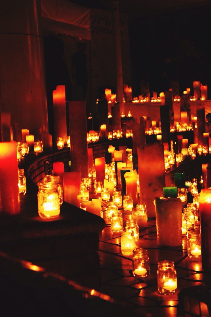 illuminated, indoors, candle, religion, night, place of worship, lit, burning, flame, glowing, lighting equipment, spirituality, fire - natural phenomenon, temple - building, table, light - natural phenomenon, decoration, close-up, focus on foreground