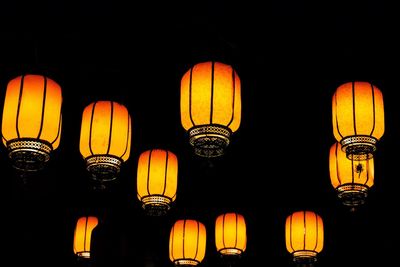 Low angle view of illuminated lanterns hanging against sky at night