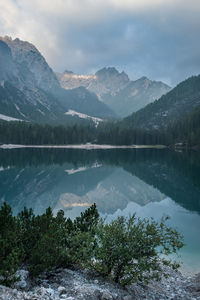 Scenic view of lake by mountains against sky