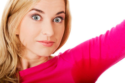 Young woman with sweat on armpit against white background