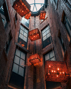 Low angle view of illuminated lanterns hanging by building