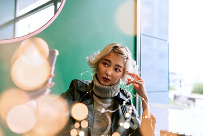 Portrait of a smiling young woman holding camera