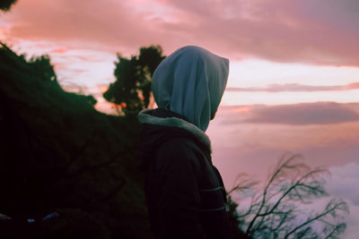 Side view of man standing against sky during sunset