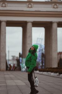 Low angle view of woman standing in city