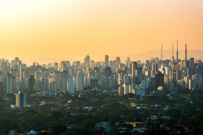 Modern buildings against sky during sunset in city