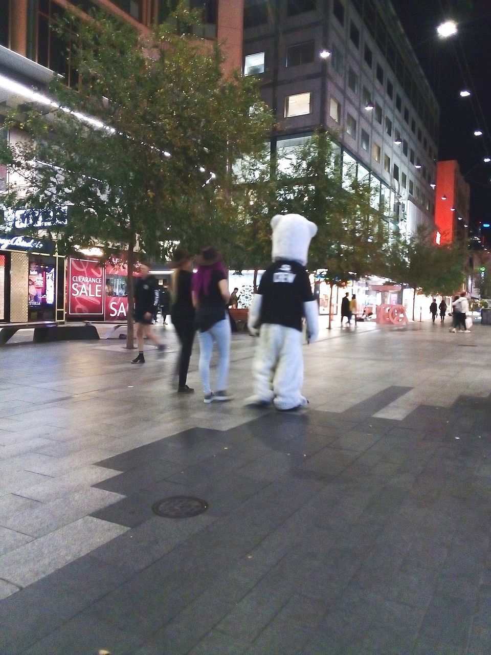 PEOPLE WALKING ON STREET AGAINST BUILDINGS IN CITY