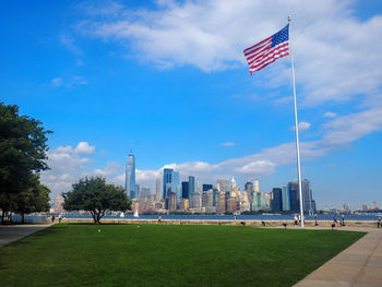 Flag in city against cloudy sky