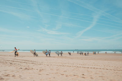 People at beach against sky