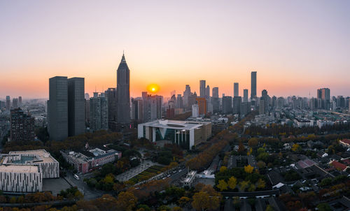 Aerial view of buildings in city during sunset