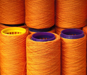 Full frame shot of orange colored spools