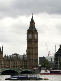 Low angle view of clock tower against cloudy sky