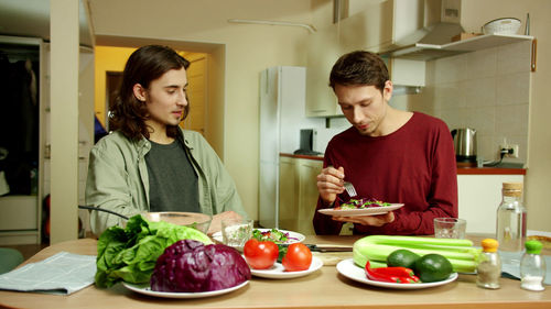 Young man and woman having food at home