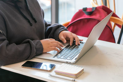 Midsection of man using laptop on table