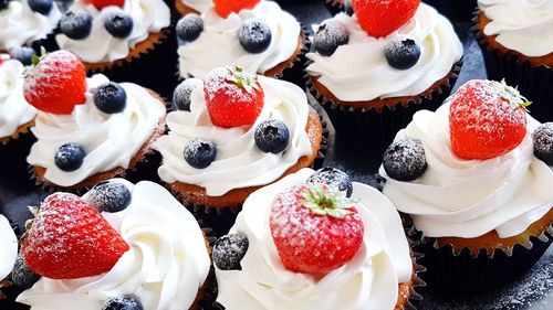 Close-up of cupcakes with strawberry and blueberries