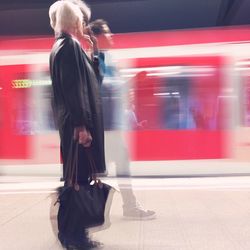 Side view of woman standing on train at subway station