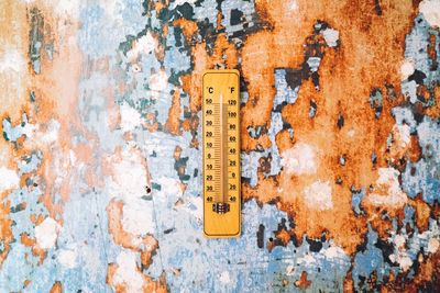 Close-up of thermometer on weathered wall