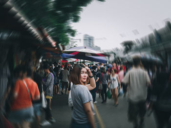 Portrait of woman standing by people in market