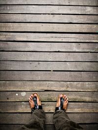 Low section of man standing on boardwalk