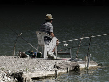 Rear view of man standing in front of river