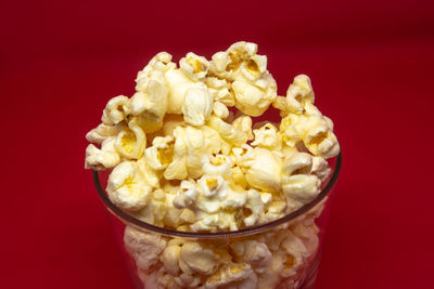 Close-up of yellow flowers in bowl against red background