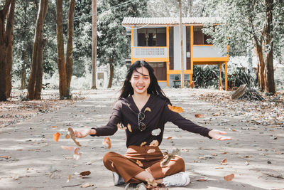 Portrait of smiling young woman sitting on land