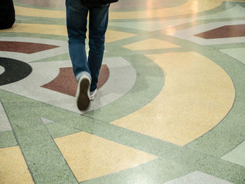 Low section of man standing on tiled floor