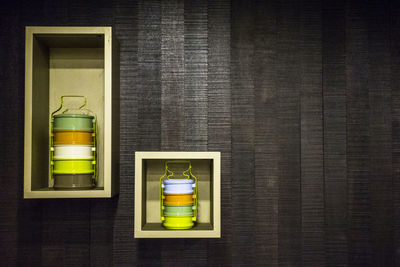 Colorful lunch boxes on wooden shelf