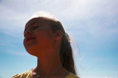 Portrait of woman looking away against sky