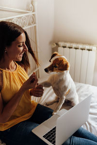 Woman with dog sitting in laptop