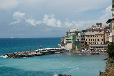 Scenic view of sea by buildings against sky