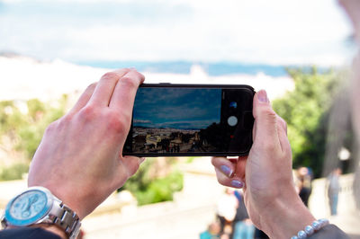 Cropped hand of woman photographing with mobile phone