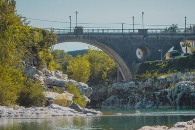 Arch bridge over river against clear sky