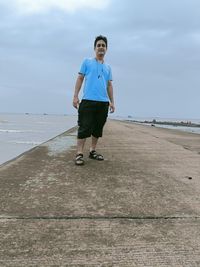 Full length of young man standing on beach