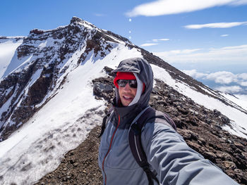 Man makes selfie on caldera of plosky tolbachik stratovolcano. hiking kamchatka peninsula. russia.
