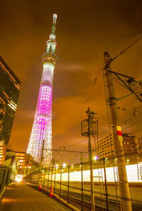 Low angle view of illuminated buildings against sky at night