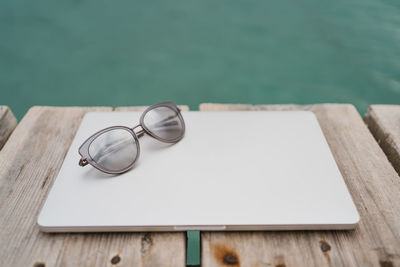 Still life of laptop and sunglasses at the ocean