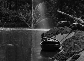 Man on boat moored by lake