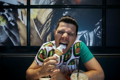 Portrait of man eating ice cream in cafe