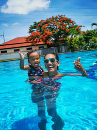 Portrait of mother and little daughter in swimming pool