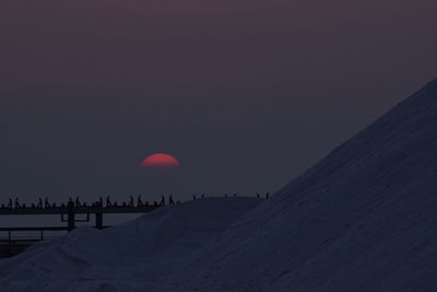 Scenic view of snowcapped landscape against sky during sunset