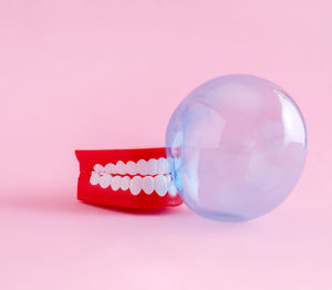 High angle view of crystal ball against pink background